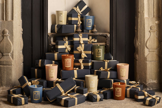 Cozy fireplace adorned with wrapped Christmas presents spilling onto the hearth, with elegant Floris scented candles artfully placed among the gifts, adding a touch of festive luxury.