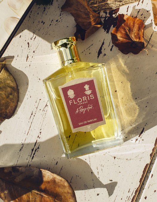 A bottle of 'A Rose For...' surrounded by autumn foliage. 