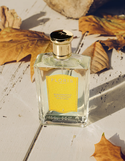 A bottle of 'Bergamotto di Positano' surrounded by autumn foliage. 