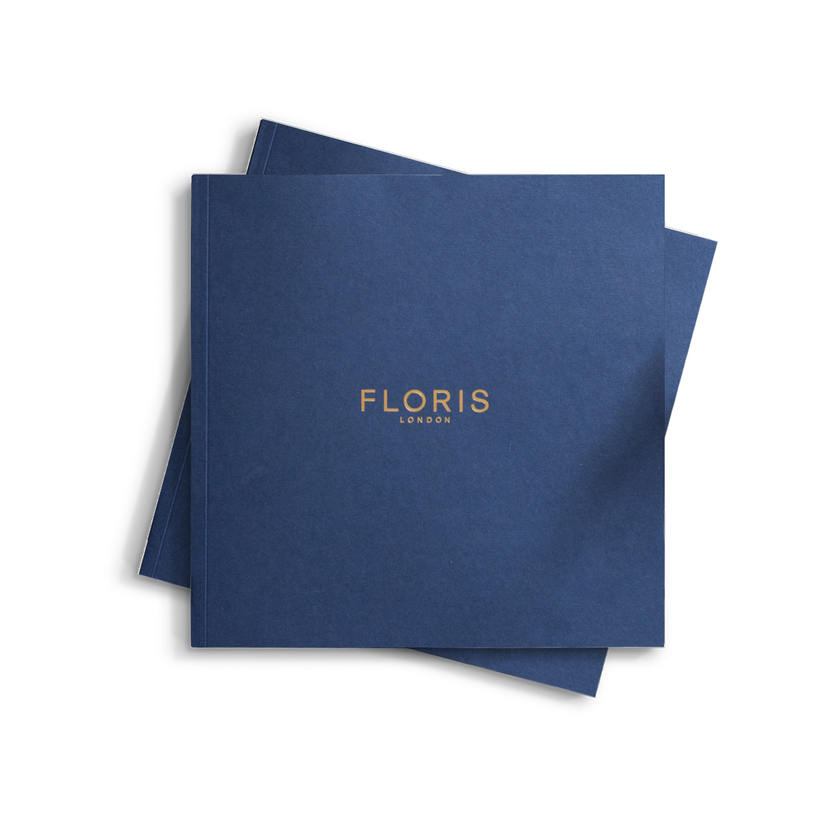 A square-shaped booklet with a navy blue cover featuring the gold-embossed text 'FLORIS LONDON' cantered on the front.