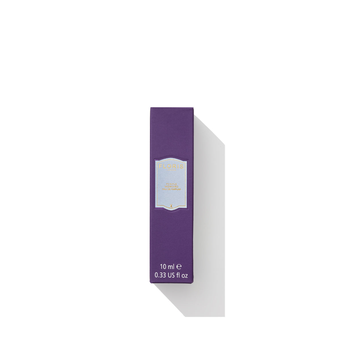 A small, rectangular purple box of Purple Mémoire - Eau de Parfum by Floris London UK features sandalwood notes and gold text on a light blue label.