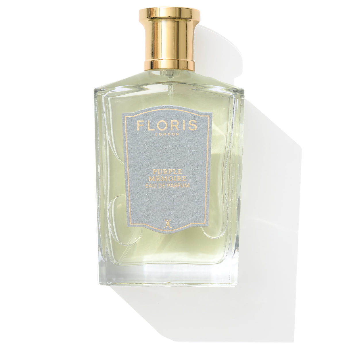 Square glass bottle with gold cap, labeled "Floris London UK Purple Mémoire - Eau de Parfum," infused with jasmine and sandalwood notes.