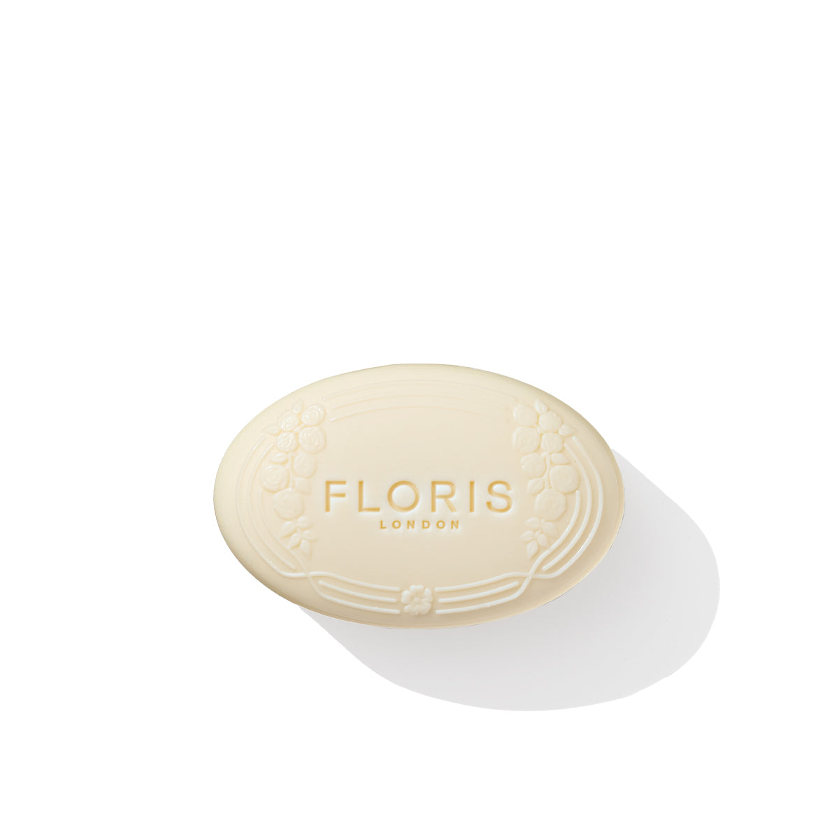 An oval-shaped Rose Geranium Soap by Floris London, adorned with floral engravings, resting on a white surface.