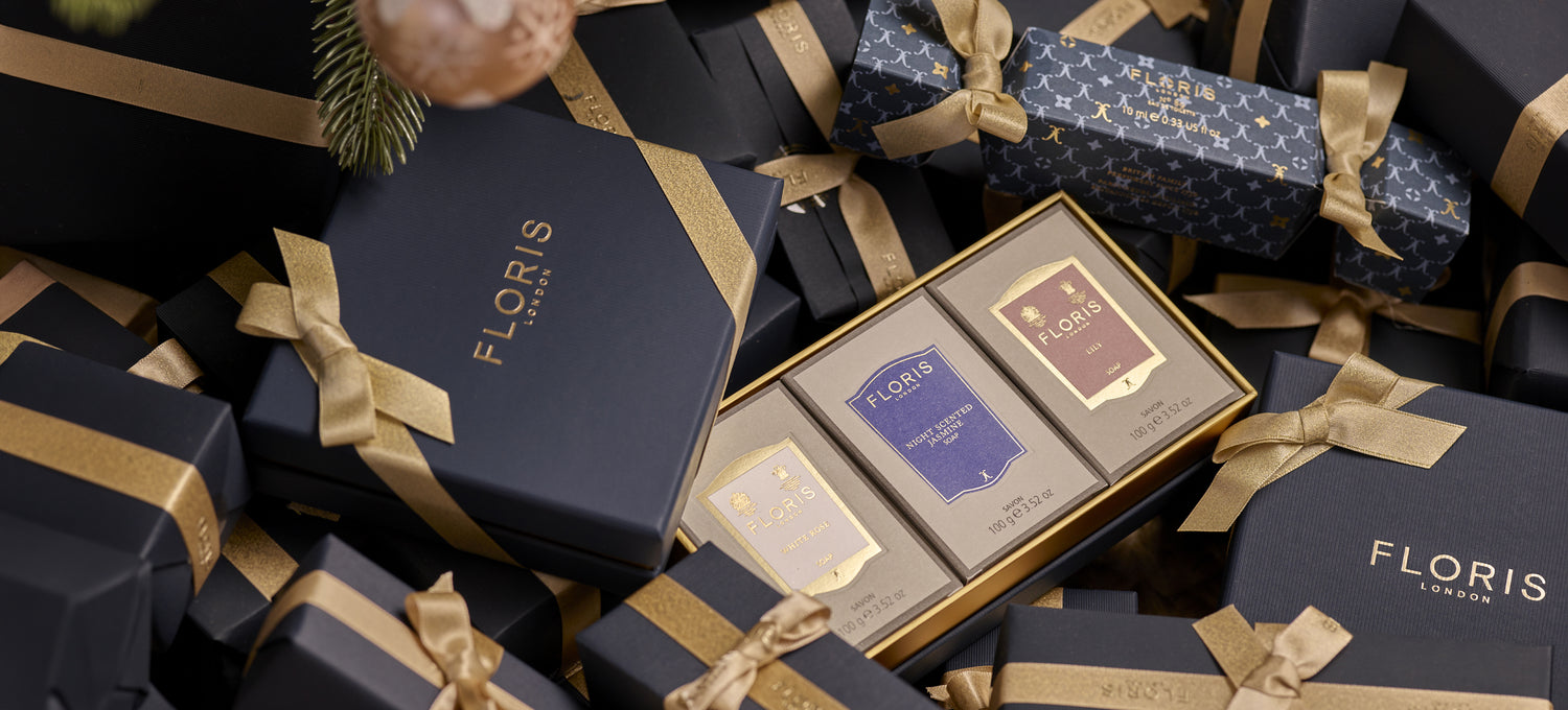 A boxed Soap Collection For Her from Floris London, featuring three exquisite soap products, nestled in-between beautifully gift wrapped presents. This luxurious gift set is perfect for the holiday season.