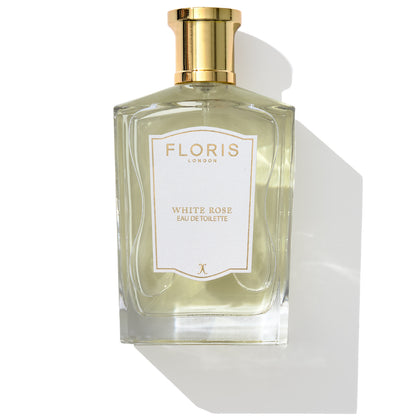 A bottle of Floris London's White Rose - Eau de Toilette, featuring a gold cap and encapsulating the essence of velvet roses, elegantly displayed against a pure white backdrop.