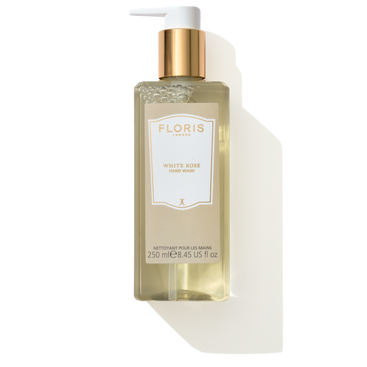 A bottle of Floris London's White Rose - Luxury Hand Wash, 250 ml, features a gold pump and an elegant beige label. Infused with coconut ingredients for a luxurious cleanse, this hand wash exudes a delightful White Rose scent.
