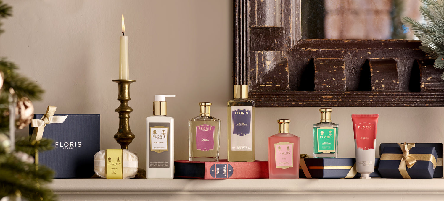 A selection of Floris Londons best selling products for 2024 placed upon a firplace, surrounded by wrapped Christmas presents and decorations.